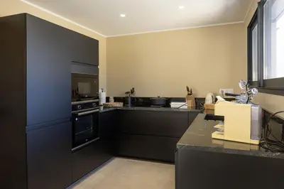 a kitchen with black cabinets and a stove top oven at Villa Vignarella in Sorbo-Ocagnano