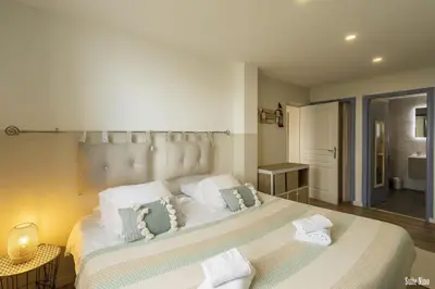 a bedroom with a large bed with white sheets and pillows at Résidence CasaBianca Porticcio - Nino in Grosseto-Prugna