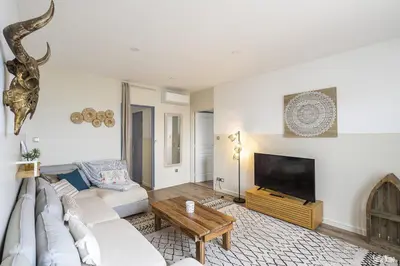 a living room with a white couch and a tv at Résidence CasaBianca Porticcio - Nino in Grosseto-Prugna