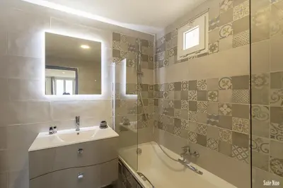 a bathroom with a sink and a tub and a mirror at Résidence CasaBianca Porticcio - Nino in Grosseto-Prugna