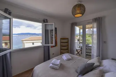 a bedroom with a bed and a large window at Résidence CasaBianca Porticcio - Paomia in Porticcio