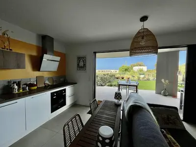a kitchen with a couch and a table in a room at Appartement jardin de livia 2 rez de jardin in Porticcio