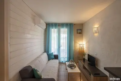 a living room with a white couch and a television at Résidence CasaBianca Porticcio - Roccapina in Porticcio