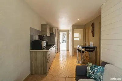 a kitchen with a couch and a counter with a microwave at Résidence CasaBianca Porticcio - Roccapina in Porticcio