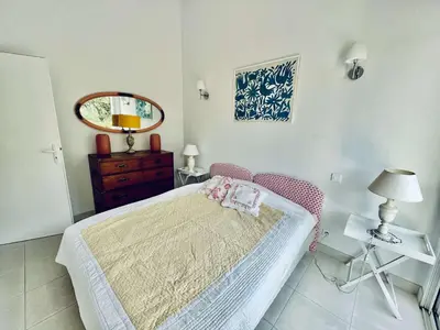 a bedroom with a bed and a dresser and a mirror at Maison 4 pièces PIETROSELLA in Pietrosella