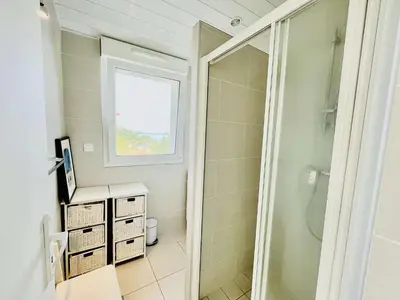 a bathroom with a shower and a sink and a mirror at Maison 4 pièces PIETROSELLA in Pietrosella