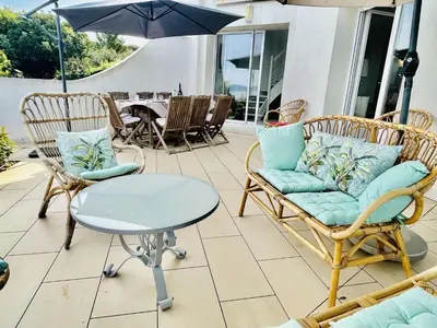 a patio with chairs and a table and an umbrella at Maison 4 pièces PIETROSELLA in Pietrosella
