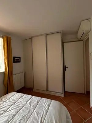 a bedroom with two sliding doors and a bed at T3 Ajaccio rte des Sanguinaires in Ajaccio