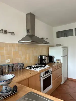 a kitchen with a stove and a refrigerator at T3 Ajaccio rte des Sanguinaires in Ajaccio