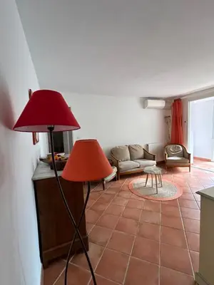 a living room with a red lamp and a couch at T3 Ajaccio rte des Sanguinaires in Ajaccio