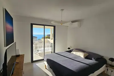 a bedroom with a bed and a view of the ocean at Nouveau Superbe appartement - Rsd Calypso Tiuccia in Casaglione