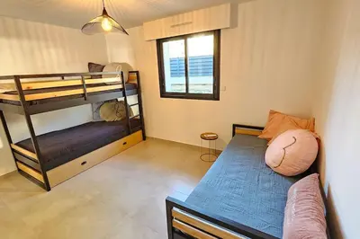 a bedroom with two bunk beds and a couch at Nouveau Superbe appartement - Rsd Calypso Tiuccia in Casaglione