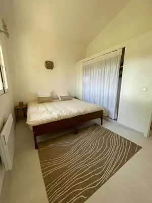 a bedroom with a bed with a rug and a window at A CASA DI SPIAGGIA in San-Nicolao