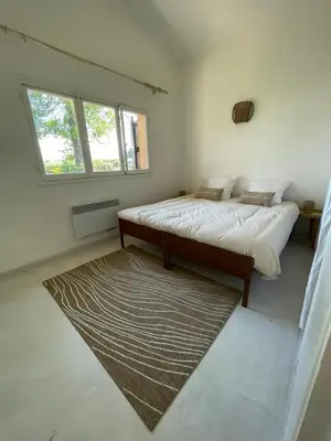 a bedroom with a large bed and a rug at A CASA DI SPIAGGIA in San-Nicolao