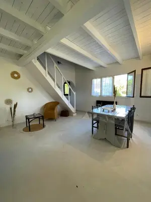 a large room with a table and a staircase at A CASA DI SPIAGGIA in San-Nicolao