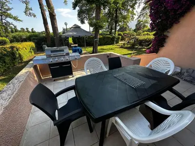 a black table and chairs on a patio with a grill at A CASA DI SPIAGGIA in San-Nicolao