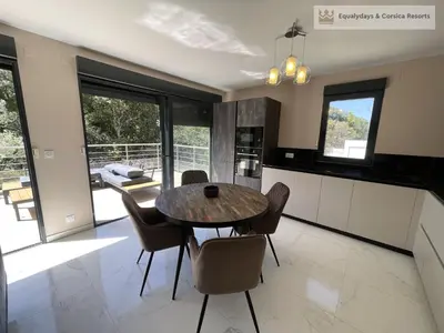 a kitchen and dining room with a table and chairs at Bonifacio Les Jardins secrets de Piale in Bonifacio