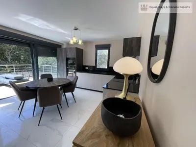 a kitchen and dining room with a table and chairs at Bonifacio Les Jardins secrets de Piale in Bonifacio