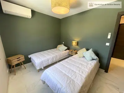 two beds in a room with green walls at Bonifacio Les Jardins secrets de Piale in Bonifacio