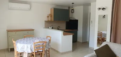 a kitchen with a table and a table and chairs at Mini villa - T2 climatisé, proche des plages in Eccica-Suarella