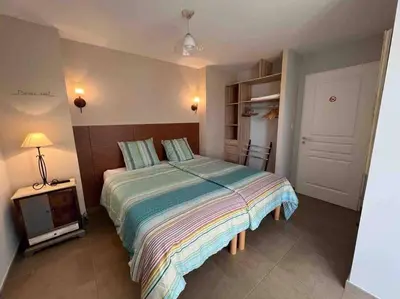 a bedroom with a bed and a tv in it at Studio 2 avec piscine & vue sur la baie d'Ajaccio in Alata
