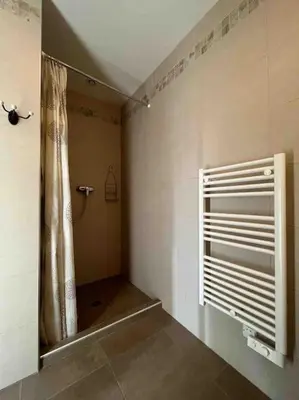 a bathroom with a shower with a mirror and a window at Studio 2 avec piscine & vue sur la baie d'Ajaccio in Alata