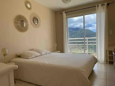 a bedroom with a large bed and a large window at Casa Antonietta Alata vue imprenable sur la mer in Alata