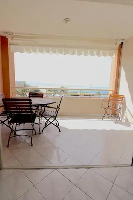 a dining room with a table and chairs and a large window at T2 ARIA MARINA Route des Sanguinaires, Vue MER, Terrasse , Parking, Plage à 50M - 4pers in Ajaccio