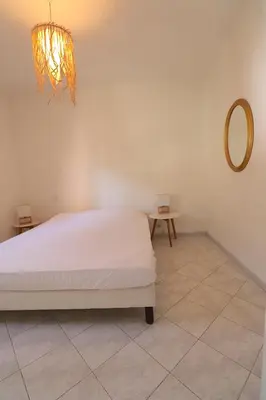 a bedroom with a white bed and a mirror at T2 ARIA MARINA Route des Sanguinaires, Vue MER, Terrasse , Parking, Plage à 50M - 4pers in Ajaccio