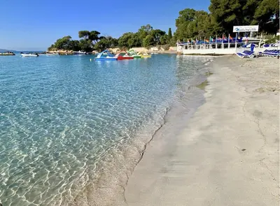 a beach with people in boats in the water at T2 ARIA MARINA Route des Sanguinaires, Vue MER, Terrasse , Parking, Plage à 50M - 4pers in Ajaccio