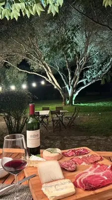a wooden table with a bottle of wine and a glass at Château Balesi Bonifacio in Bonifacio