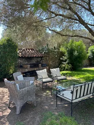 a group of chairs and a fire place in a yard at Château Balesi Bonifacio in Bonifacio