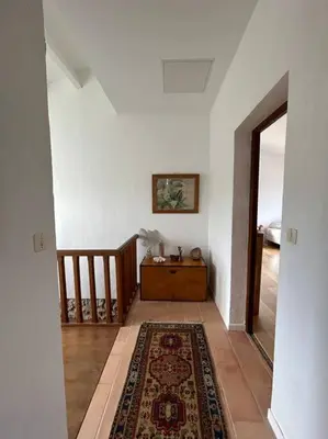 a hallway with a staircase and a rug on a floor at Château Balesi Bonifacio in Bonifacio