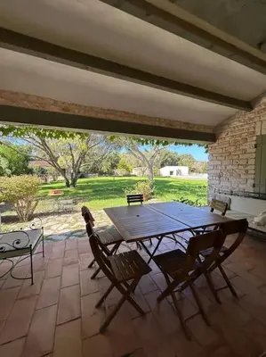 a wooden table and chairs on a patio at Château Balesi Bonifacio in Bonifacio
