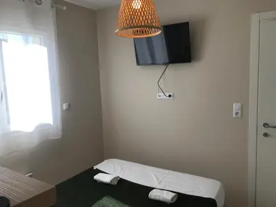 a small room with a bed and a lamp at Appartement bord de mer T4 marina di bravonne N5-6 in Linguizzetta