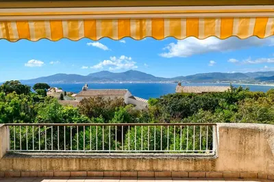 a view of the ocean from a balcony of a house at Charmante maison Porticcio in Porticcio