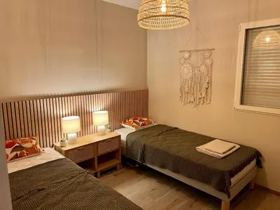a bedroom with two beds and a chandelier at joli T4 centre ville Porticcio in Grosseto-Prugna