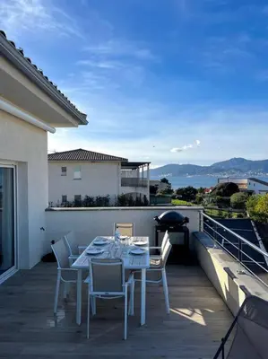 a patio with a table and chairs on a balcony at joli T4 centre ville Porticcio in Grosseto-Prugna