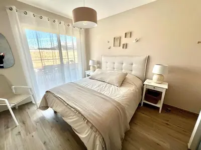 a white bedroom with a bed and a window at joli T4 centre ville Porticcio in Grosseto-Prugna