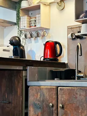 a kitchen with a red tea kettle on a counter at Casaluna, centre village, joli petit studio in Sotta