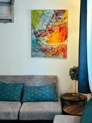 a couch in a room with a painting on the wall at Casaluna, centre village, joli petit studio in Sotta