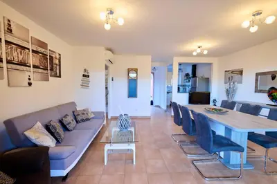 a living room with a couch and a table at Beau 3 pièces avec jardinet et cour, 5 min plages in Propriano