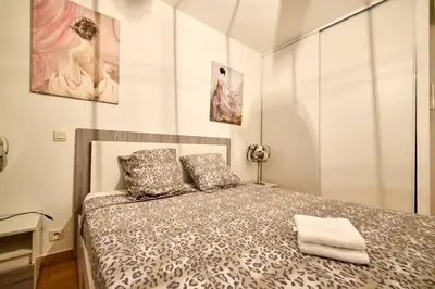 a bedroom with a bed and two paintings on the wall at Beau 3 pièces avec jardinet et cour, 5 min plages in Propriano