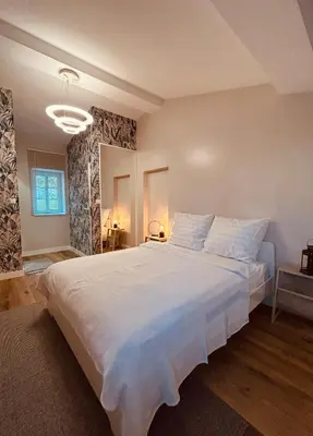 a bedroom with a large white bed in a room at Appartement au centre du Port de Bonifacio in Bonifacio