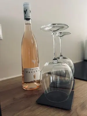 a bottle of wine sitting next to a wine glass at Appartement au centre du Port de Bonifacio in Bonifacio