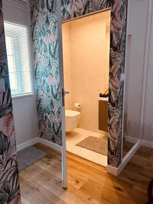 a bathroom with a toilet and a door in a room at Appartement au centre du Port de Bonifacio in Bonifacio