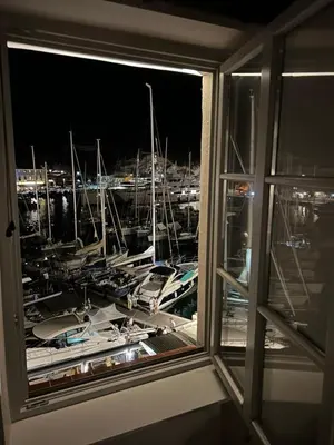 a window with a view of a marina at night at Appartement au centre du Port de Bonifacio in Bonifacio