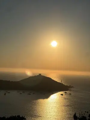 a sun setting over a small island in the ocean at Lavallee4 in Belvédère