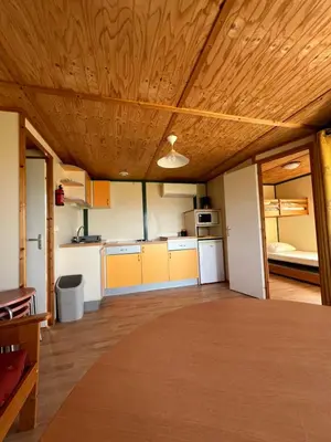 a large room with a kitchen with a wooden ceiling at Lavallee4 in Belvédère
