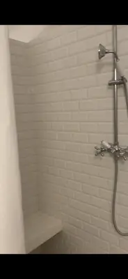 a bathroom with a shower with a bench in it at Domaine du Couvent de Saint Julien in Bonifacio